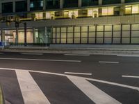 an image of outside of the night time building with the lights turned on and the streets empty