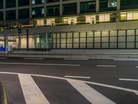 an image of outside of the night time building with the lights turned on and the streets empty