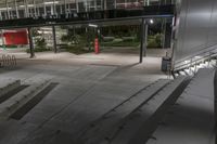 an empty walkway lined with steps leading to a building at night time as seen from above