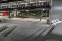 an empty walkway lined with steps leading to a building at night time as seen from above