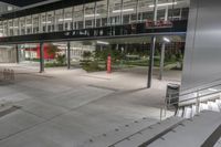 an empty walkway lined with steps leading to a building at night time as seen from above