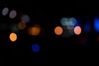 a dark, lit image with a blurry background that shows many multi - colored lights in different shades