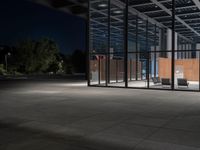 a concrete floor at night with lights on it, and chairs on the side of it