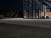 a concrete floor at night with lights on it, and chairs on the side of it