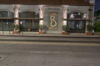 an empty city street with a brick building at night, and the words, 66, in front of it