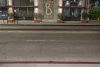 an empty city street with a brick building at night, and the words, 66, in front of it