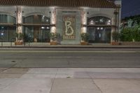 an empty city street with a brick building at night, and the words, 66, in front of it