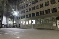 the bright lights are reflecting off of the windows on a building in an urban area