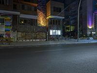 a dark city street at night with bicycles parked in the middle of it at night