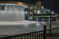 a bus stopped at the bus stop, with lights on it's roof, is lit up