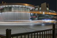 a bus stopped at the bus stop, with lights on it's roof, is lit up