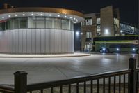 a bus stopped at the bus stop, with lights on it's roof, is lit up