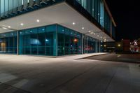 an empty building with a lot of glass on the outside of it at night with no one inside the glass