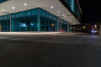 an empty building with a lot of glass on the outside of it at night with no one inside the glass