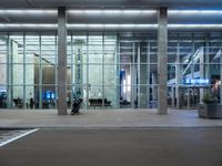 an empty parking lot is pictured at an airport terminal with glass walls on both sides