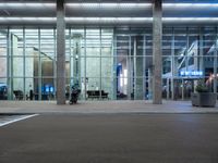 an empty parking lot is pictured at an airport terminal with glass walls on both sides