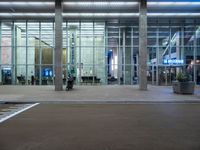 an empty parking lot is pictured at an airport terminal with glass walls on both sides