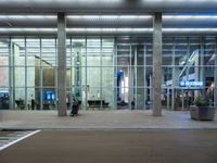 an empty parking lot is pictured at an airport terminal with glass walls on both sides