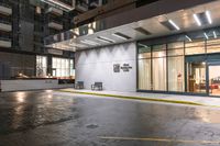 car driving past a modern building with glass windows at night time, in the rain