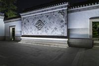 a building at night with a light on it's sides and a stone facade