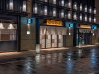 a large brick sidewalk with a store front at night time and a sign that says