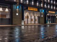 a large brick sidewalk with a store front at night time and a sign that says