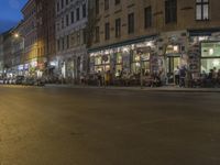 the street has light streaks from cars coming in the window of it and a building that is empty