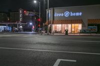 there is a crosswalk that has people walking across it at night outside a local business