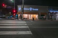 there is a crosswalk that has people walking across it at night outside a local business