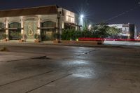 the city is in an empty lot at night, with traffic passing through the intersection