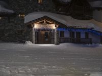 a small cabin is adorned with blue christmas lights and stars in the snow at night