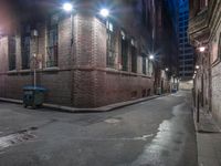 a large building sitting in the middle of a alley at night with a blue box in the corner