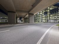 there is an empty parking lot outside a building by the street corner at night time