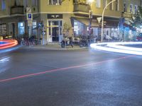 a street with a fire hydrant, some bikes and buildings at night or early