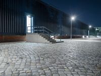 brick walkway that has steps and stairs to the outside of it, with lights on all of them