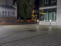 street lights on the sidewalk and a brick wall behind them that is empty outside with a small area of water around