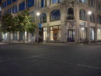 cars and bicyclists are driving along this empty street in front of many old buildings