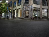 cars and bicyclists are driving along this empty street in front of many old buildings