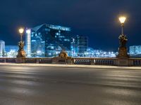 a street view of a city at night with lights reflecting on the street and buildings