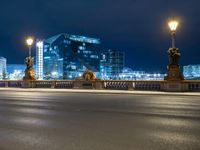 a street view of a city at night with lights reflecting on the street and buildings