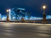 a street view of a city at night with lights reflecting on the street and buildings