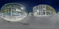 a fish eye view of an intersection and building site at night time with buildings on both sides