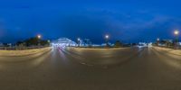 a full view of the street in the evening at night, showing the bright lights and the speed lane