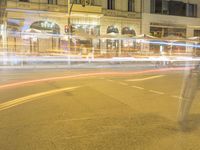 city street at night with the traffic blurry from a car light streaks along the road