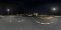 a circular shaped photograph shows a street at night, and a building is in the distance