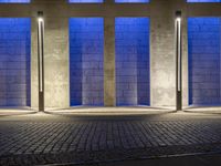 the side walk on an empty brick building in a blue light place on a sunny day