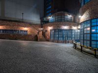 some dark blue windows in an industrial building with no one on the street to the right