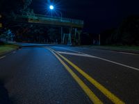 an empty highway is lit by street lights at night time, with no traffic or pedestrians