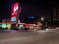 a city street lit up at night in the usa with the lights on and stores lining both sides of the road