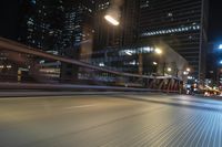 the blurry shot of an empty street at night shows off many tall buildings and buildings